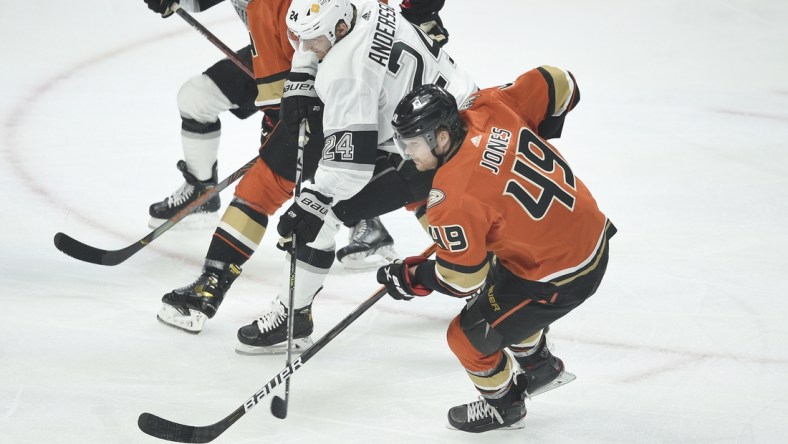 Apr 28, 2021; Los Angeles, California, USA; Los Angeles Kings center Lias Andersson (24) moves the puck while defended by Anaheim Ducks left wing Max Jones (49) during the first period at Staples Center. Mandatory Credit: Kelvin Kuo-USA TODAY Sports