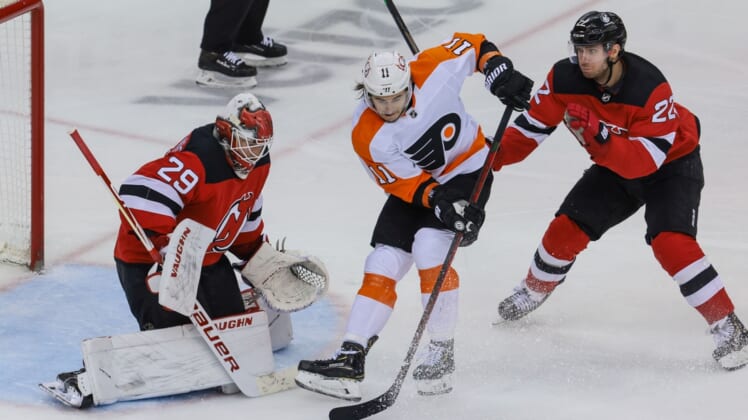 Apr 29, 2021; Newark, New Jersey, USA; Philadelphia Flyers right wing Travis Konecny (11) deflects the puck in front of New Jersey Devils goaltender Mackenzie Blackwood (29) as defenseman Ryan Murray (22) defends during the second period at Prudential Center. Mandatory Credit: Vincent Carchietta-USA TODAY Sports