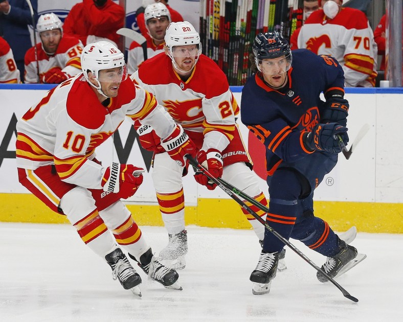 Apr 29, 2021; Edmonton, Alberta, CAN; Calgary Flames forward Derek Ryan (10) and Edmonton Oilers forward Gaetan Haas (91) look for a loose puck during the first period at Rogers Place. Mandatory Credit: Perry Nelson-USA TODAY Sports