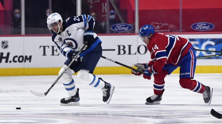 Apr 30, 2021; Montreal, Quebec, CAN; Winnipeg Jets forward Blake Wheeler (26) skates with the puck and Montreal Canadiens forward Nick Suzuki (14) defends during the first period at the Bell Centre. Mandatory Credit: Eric Bolte-USA TODAY Sports