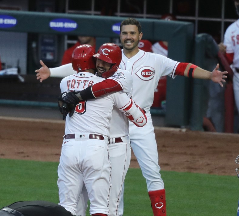Apr 30, 2021; Cincinnati, Ohio, USA; Cincinnati Reds first baseman Joey Votto (19) reacts with right fielder Nick Castellanos (middle) and shortstop Eugenio Suarez (right) after hitting a two-run home run, the 300th of his major league career during the third inning against the Chicago Cubs at Great American Ball Park. Mandatory Credit: David Kohl-USA TODAY Sports