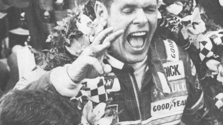 Bobby Unser shouts for joy in Victory Lane with the wreath of orchids around his shoulders and the Borg-Warner trophy behind him on May 24, 1981.Unser