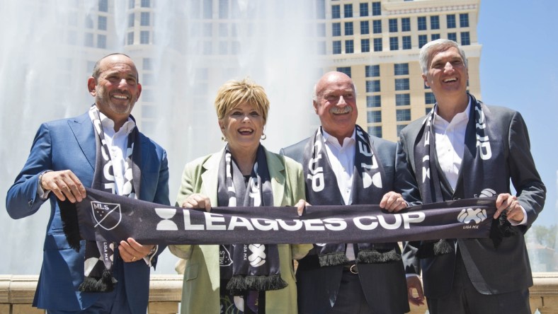 Jul 11, 2019; Las Vegas, NV, USA; From left, Major League Soccer commissioner Don Garber, Las Vegas mayor Carolyn G. Goodman, Liga MX Executive president Enrique Bonilla, and MGM President of Entertainment and sports George Kliavkoff pose for a photo in front of the Bellagio Hotel and Casino fountains. Mandatory Credit: Daniel Clark-USA TODAY Sports