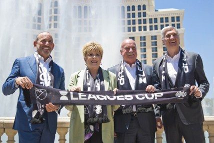 Jul 11, 2019; Las Vegas, NV, USA; From left, Major League Soccer commissioner Don Garber, Las Vegas mayor Carolyn G. Goodman, Liga MX Executive president Enrique Bonilla, and MGM President of Entertainment and sports George Kliavkoff pose for a photo in front of the Bellagio Hotel and Casino fountains. Mandatory Credit: Daniel Clark-USA TODAY Sports
