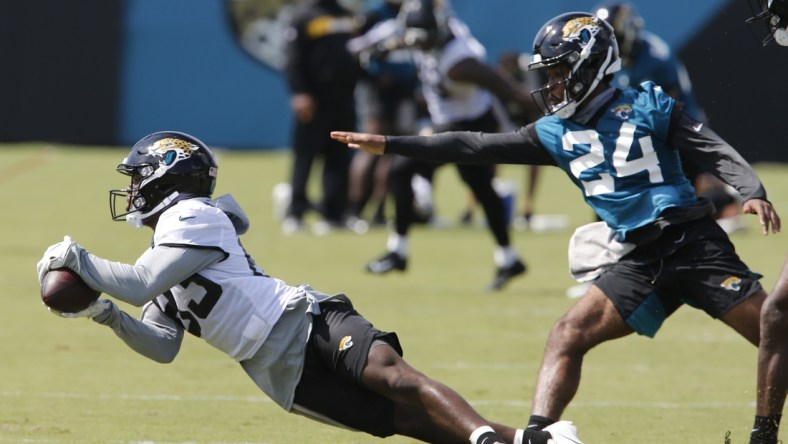 Aug 16, 2020; Jacksonville, Florida, United States;  Jacksonville Jaguars wide receiver Marvelle Ross (83) dives for a pass as corner back Josiah Scott (24) defends defends during training camp drills at the Dream Finders Homes training facility. Mandatory Credit: Reinhold Matay-USA TODAY Sports