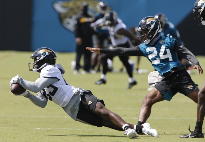 Aug 16, 2020; Jacksonville, Florida, United States;  Jacksonville Jaguars wide receiver Marvelle Ross (83) dives for a pass as corner back Josiah Scott (24) defends defends during training camp drills at the Dream Finders Homes training facility. Mandatory Credit: Reinhold Matay-USA TODAY Sports