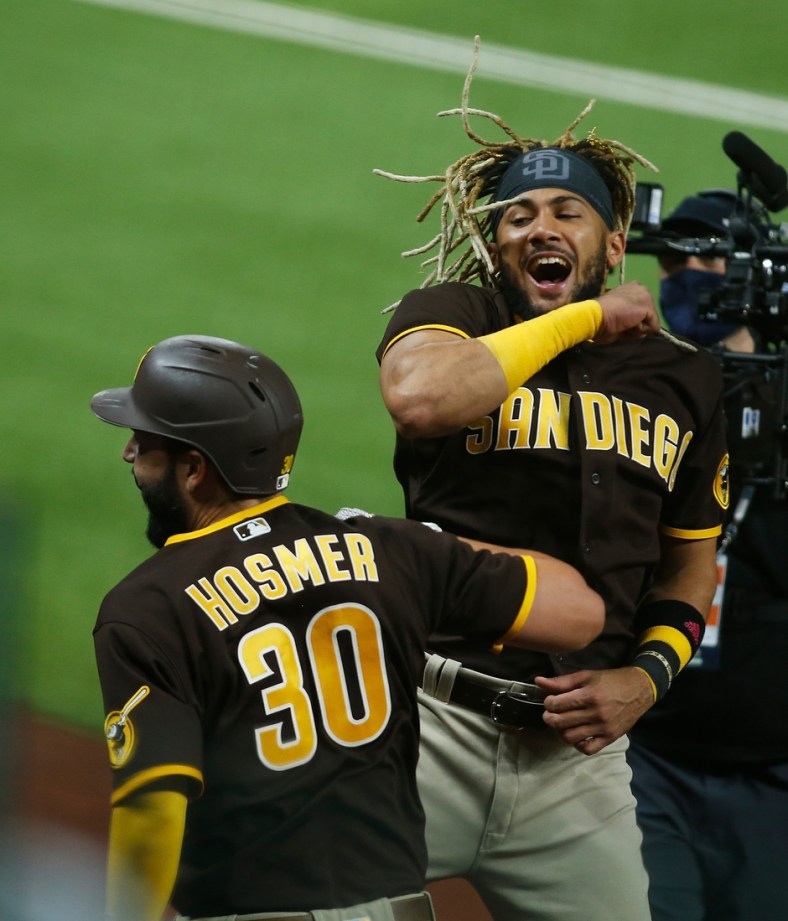 Oct 7, 2020; Arlington, Texas, USA; San Diego Padres first baseman Eric Hosmer (30) is congratulated by shortstop Fernando Tatis Jr. (23) after hitting a solo home run off of Los Angeles Dodgers starting pitcher Clayton Kershaw (not pictured) during the sixth inning in game two of the 2020 NLDS at Globe Life Field. Mandatory Credit: Tim Heitman-USA TODAY Sports
