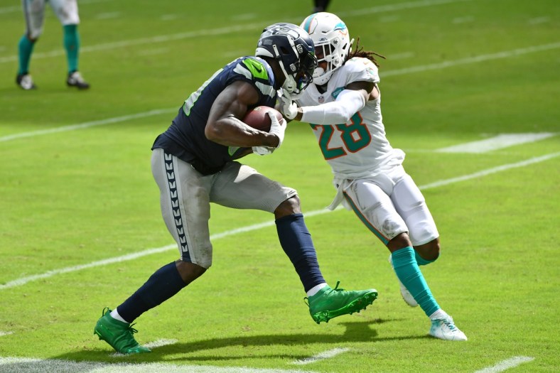 Oct 4, 2020; Miami Gardens, Florida, USA; Miami Dolphins strong safety Bobby McCain (28) attempts to tackle Seattle Seahawks wide receiver DK Metcalf (14) during the second half at Hard Rock Stadium. Mandatory Credit: Jasen Vinlove-USA TODAY Sports