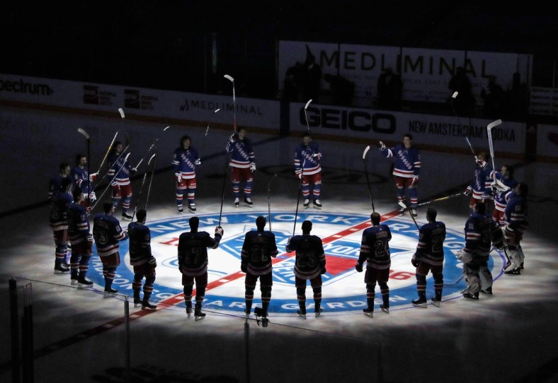 Jan 14, 2021; New York, NY, USA;  New York Rangers players huddle around the center ice logo as they prepare for the home opener against the New York Islanders at Madison Square Garden.  Mandatory Credit: Bruce Bennett/Pool Photo via USA TODAY Sports