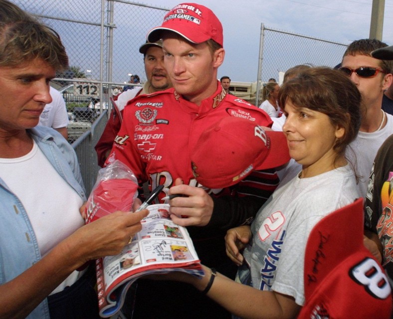 Dale Earnhardt Jr, is surrounded by fans as he heads to the garage area for practice at Daytona Interrnational Speedway, Thursday, July 5, 2001.