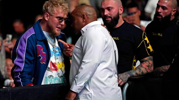Apr 24, 2021; Jacksonville, Florida, USA; YouTube star Jake Paul is confronted by UFC ringside announcer Daniel Cormier before Anthony Smith (Red Gloves) fights Jimmy Crute (Blue Gloves) during UFC 261 at VyStar Veterans Memorial Arena. Mandatory Credit: Jasen Vinlove-USA TODAY Sports