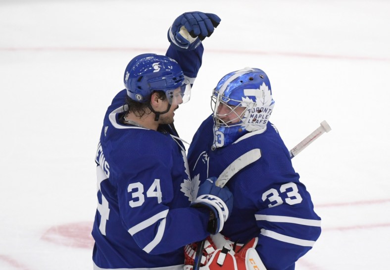 Apr 29, 2021; Toronto, Ontario, CAN;  Toronto Maple Leafs forward Auston Matthews (34) greets goalie David Rittich (33) as they celebrate a win over Vancouver Canucks at Scotiabank Arena. Mandatory Credit: Dan Hamilton-USA TODAY Sports