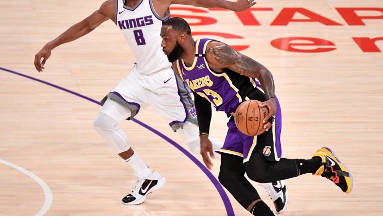 Apr 30, 2021; Los Angeles, California, USA; Los Angeles Lakers forward LeBron James (23) dribbles past Sacramento Kings forward Maurice Harkless (8) during the first quarter at Staples Center. James returned to the Lakers lineup after recovering from an ankle injury. Mandatory Credit: Robert Hanashiro-USA TODAY Sports