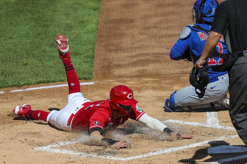 May 1, 2021; Cincinnati, Ohio, USA; Cincinnati Reds right fielder Tyler Naquin (12) slides into home plate against the Chicago Cubs during the first inning at Great American Ball Park. Mandatory Credit: Katie Stratman-USA TODAY Sports