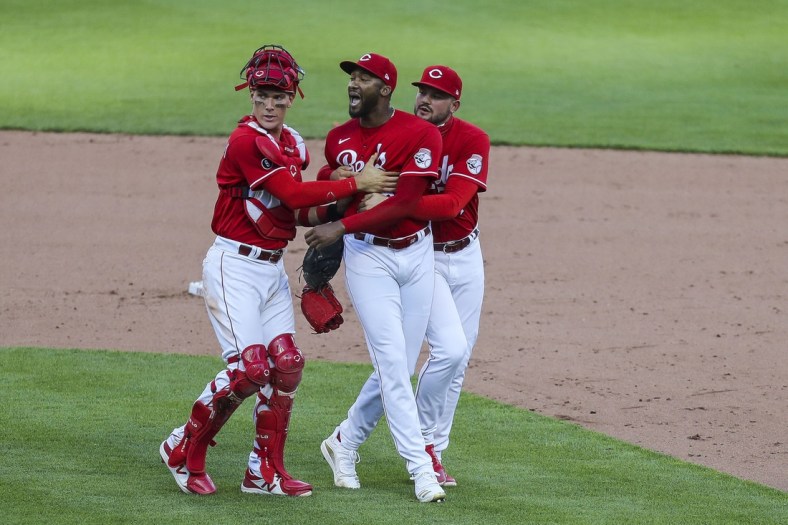 May 1, 2021; Cincinnati, Ohio, USA; Cincinnati Reds catcher Tyler Stephenson (37) and relief pitcher Sal Romano (47) hold back relief pitcher Amir Garrett (50) during an argument with the Chicago Cubs in the eighth  inning at Great American Ball Park. Mandatory Credit: Katie Stratman-USA TODAY Sports
