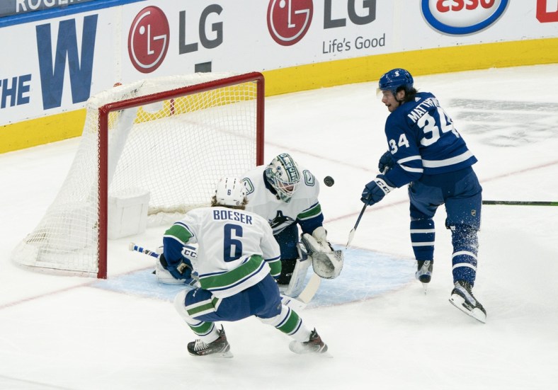 May 1, 2021; Toronto, Ontario, CAN; Toronto Maple Leafs center Auston Matthews (34) battles for a puck in front of Vancouver Canucks goaltender Thatcher Demko (35) during the first period at Scotiabank Arena. Mandatory Credit: Nick Turchiaro-USA TODAY Sports