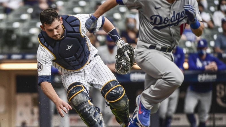 May 1, 2021; Milwaukee, Wisconsin, USA; Milwaukee Brewers catcher Luke Maile (12) throws out Los Angeles Dodgers catcher Austin Barnes (15) in the third inning at American Family Field. Mandatory Credit: Benny Sieu-USA TODAY Sports