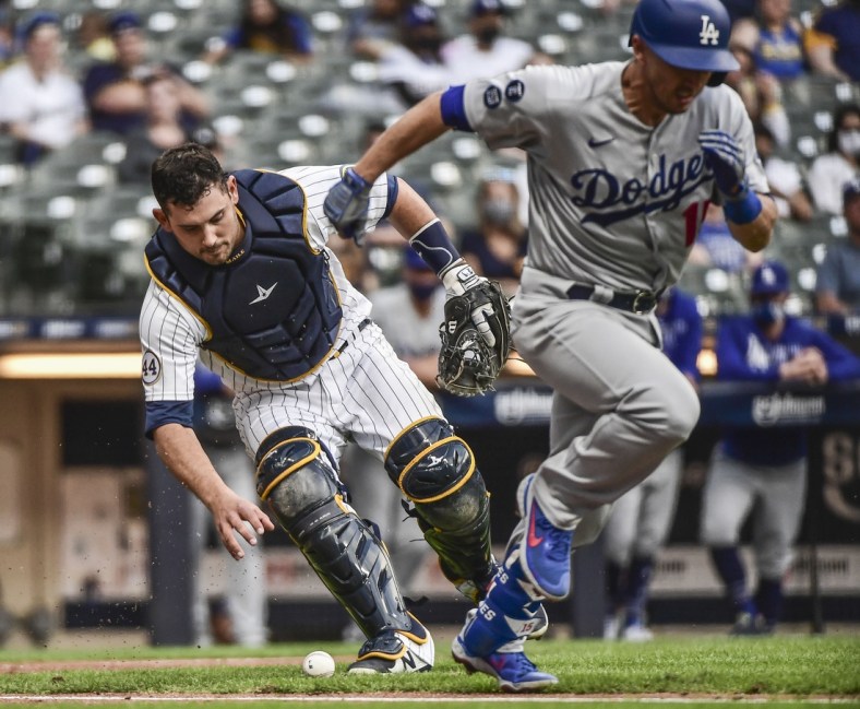 May 1, 2021; Milwaukee, Wisconsin, USA; Milwaukee Brewers catcher Luke Maile (12) throws out Los Angeles Dodgers catcher Austin Barnes (15) in the third inning at American Family Field. Mandatory Credit: Benny Sieu-USA TODAY Sports