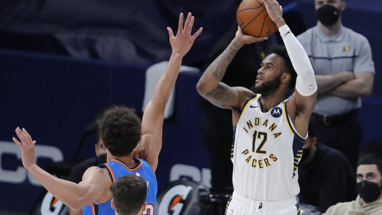 May 1, 2021; Oklahoma City, Oklahoma, USA; Indiana Pacers forward Oshae Brissett (12) shoots a three-point basket as Oklahoma City Thunder center Isaiah Roby (22) defends during the second quarter at Chesapeake Energy Arena. Mandatory Credit: Alonzo Adams-USA TODAY Sports