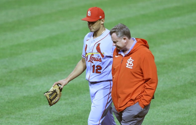 May 1, 2021; Pittsburgh, Pennsylvania, USA;  St. Louis Cardinals relief pitcher Jordan Hicks (12) leaves the field with a team trainer after suffering an apparent injury pitching against the Pittsburgh Pirates during the seventh inning at PNC Park. The Cardinals won 12-5. Mandatory Credit: Charles LeClaire-USA TODAY Sports