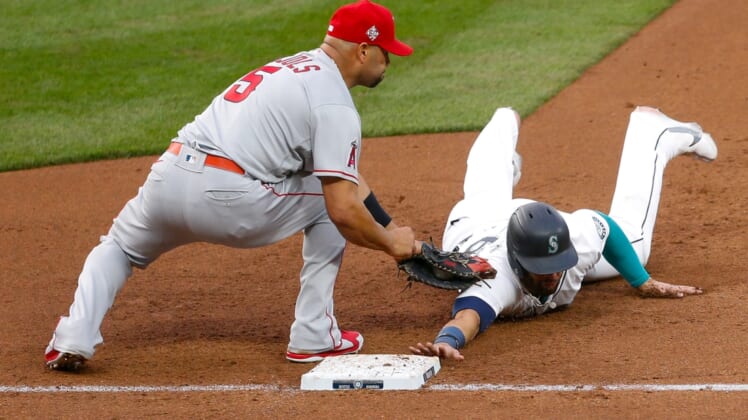 May 1, 2021; Seattle, Washington, USA; Seattle Mariners designated hitter Jose Marmolejos (26) get picked off by Los Angeles Angels first baseman Albert Pujols (5) during the fourth inning at T-Mobile Park. Mandatory Credit: Jennifer Buchanan-USA TODAY Sports