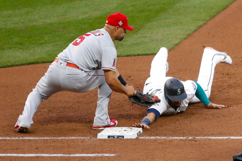 May 1, 2021; Seattle, Washington, USA; Seattle Mariners designated hitter Jose Marmolejos (26) get picked off by Los Angeles Angels first baseman Albert Pujols (5) during the fourth inning at T-Mobile Park. Mandatory Credit: Jennifer Buchanan-USA TODAY Sports