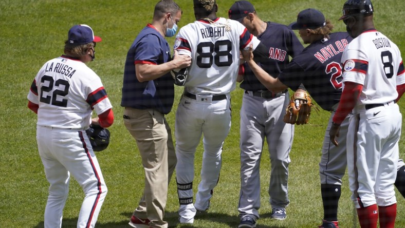 May 2, 2021; Chicago, Illinois, USA; Chicago White Sox center fielder Luis Robert (88) is helped up following an injury after beating out an infield single and had to leave the game against the Cleveland Indians during the first inning at Guaranteed Rate Field. Mandatory Credit: David Banks-USA TODAY Sports