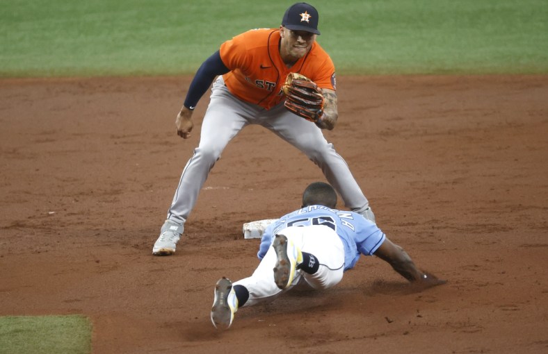 May 2, 2021; St. Petersburg, Florida, USA; Tampa Bay Rays left fielder Randy Arozarena (56) slides safely into second base as he steals and Houston Astros shortstop Carlos Correa (1) attempted to tag him out during the third inning  at Tropicana Field. Mandatory Credit: Kim Klement-USA TODAY Sports