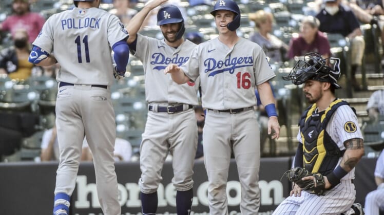 May 2, 2021; Milwaukee, Wisconsin, USA; Los Angeles Dodgers left fielder AJ Pollock (11) celebrates with left fielder Chris Taylor (3) and catcher Will Smith (16) after hitting a 3-run homer in the sixth inning as Milwaukee Brewers catcher Jacob Nottingham (26) watches at American Family Field. Mandatory Credit: Benny Sieu-USA TODAY Sports