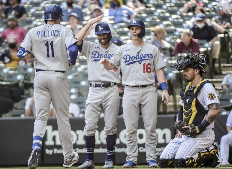 May 2, 2021; Milwaukee, Wisconsin, USA; Los Angeles Dodgers left fielder AJ Pollock (11) celebrates with left fielder Chris Taylor (3) and catcher Will Smith (16) after hitting a 3-run homer in the sixth inning as Milwaukee Brewers catcher Jacob Nottingham (26) watches at American Family Field. Mandatory Credit: Benny Sieu-USA TODAY Sports