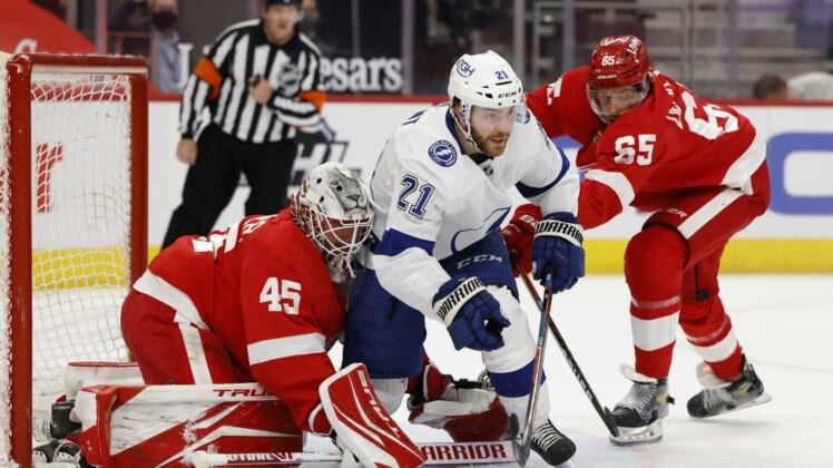May 2, 2021; Detroit, Michigan, USA;  Tampa Bay Lightning center Brayden Point (21) fights for position with Detroit Red Wings defenseman Danny DeKeyser (65) in front of goaltender Jonathan Bernier (45) in the first period at Little Caesars Arena. Mandatory Credit: Rick Osentoski-USA TODAY Sports