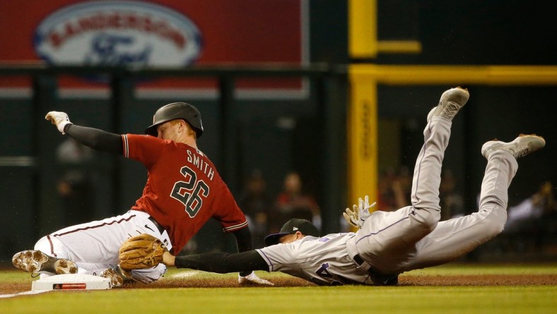 May 2, 2021; Phoenix, Arizona, USA; Rockies' Ryan McMahon (24) dives and tags out Diamondbacks' Pavin Smith (26) as he slides into third during the first inning at Chase Field. Patrick Breen-Arizona Republic

Mlb Rockies Vs Diamondbacks