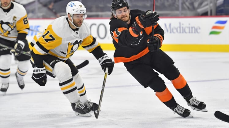May 3, 2021; Philadelphia, Pennsylvania, USA;  Philadelphia Flyers right wing Travis Konecny (11) skates past Pittsburgh Penguins right wing Bryan Rust (17) during the first period at Wells Fargo Center. Mandatory Credit: Eric Hartline-USA TODAY Sports