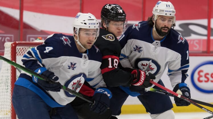 May 3, 2021; Ottawa, Ontario, CAN; Winnipeg Jets defenseman Neal Pionk (4) and center Nate Thompson (11) defend against Ottawa Senators left wing Tim St tzle (18) in the second period at the Canadian Tire Centre. Mandatory Credit: Marc DesRosiers-USA TODAY Sports