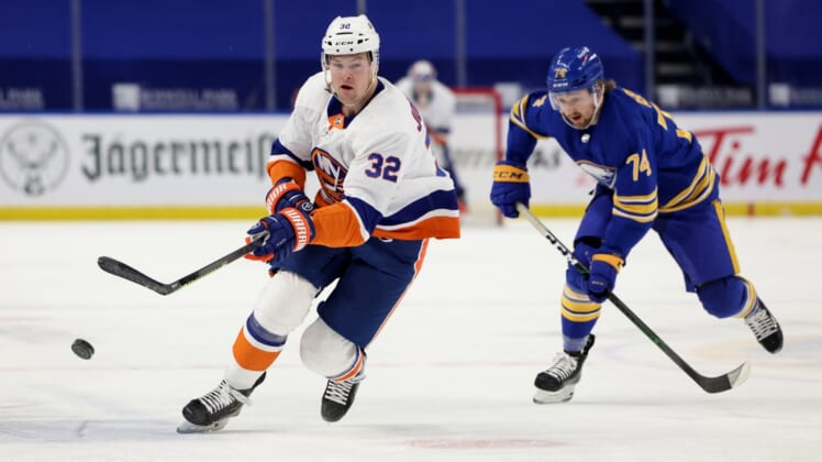 May 4, 2021; Buffalo, New York, USA;  New York Islanders left wing Ross Johnston (32) shoots the puck up ice as Buffalo Sabres center Rasmus Asplund (74) tries to defend during the first period at KeyBank Center. Mandatory Credit: Timothy T. Ludwig-USA TODAY Sports