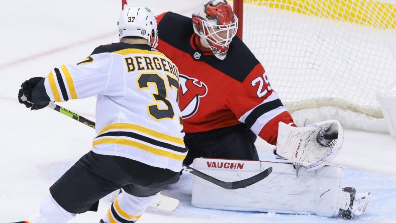 May 4, 2021; Newark, New Jersey, USA; New Jersey Devils goaltender Mackenzie Blackwood (29) makes a glove save in front of Boston Bruins center Patrice Bergeron (37) during the first period at Prudential Center. Mandatory Credit: Vincent Carchietta-USA TODAY Sports