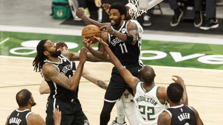 May 4, 2021; Milwaukee, Wisconsin, USA;  Brooklyn Nets center DeAndre Jordan (6), guard Kyrie Irving (11) and  Milwaukee Bucks forward Khris Middleton (22) reach for a rebound during the first quarter at Fiserv Forum. Mandatory Credit: Jeff Hanisch-USA TODAY Sports