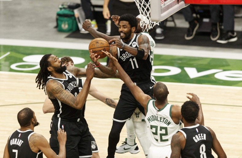 May 4, 2021; Milwaukee, Wisconsin, USA;  Brooklyn Nets center DeAndre Jordan (6), guard Kyrie Irving (11) and  Milwaukee Bucks forward Khris Middleton (22) reach for a rebound during the first quarter at Fiserv Forum. Mandatory Credit: Jeff Hanisch-USA TODAY Sports