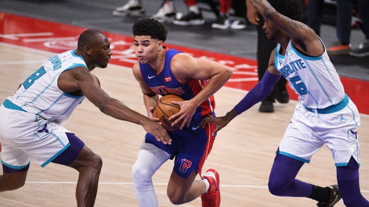 May 4, 2021; Detroit, Michigan, USA; Detroit Pistons guard Killian Hayes (7) drives to the basket as Charlotte Hornets center Bismack Biyombo (8) and forward Jalen McDaniels (6) defend during the second quarter at Little Caesars Arena. Mandatory Credit: Tim Fuller-USA TODAY Sports