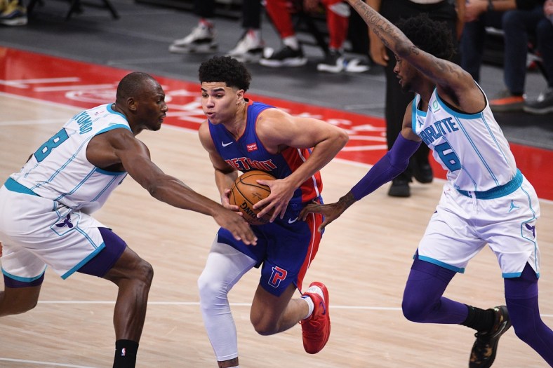 May 4, 2021; Detroit, Michigan, USA; Detroit Pistons guard Killian Hayes (7) drives to the basket as Charlotte Hornets center Bismack Biyombo (8) and forward Jalen McDaniels (6) defend during the second quarter at Little Caesars Arena. Mandatory Credit: Tim Fuller-USA TODAY Sports