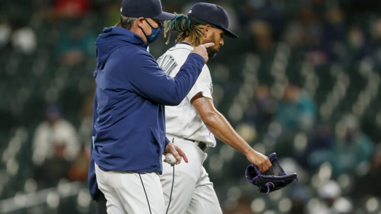 May 4, 2021; Seattle, Washington, USA; Seattle Mariners manager Scott Servais (left) signals for a new pitcher as relief pitcher Keynan Middleton (99) leaves the mound after suffering an injury during the ninth inning against the Baltimore Orioles at T-Mobile Park. Mandatory Credit: Joe Nicholson-USA TODAY Sports