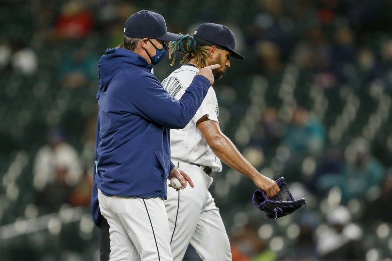 May 4, 2021; Seattle, Washington, USA; Seattle Mariners manager Scott Servais (left) signals for a new pitcher as relief pitcher Keynan Middleton (99) leaves the mound after suffering an injury during the ninth inning against the Baltimore Orioles at T-Mobile Park. Mandatory Credit: Joe Nicholson-USA TODAY Sports