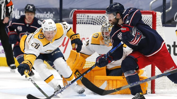 May 5, 2021; Columbus, Ohio, USA; Columbus Blue Jackets right wing Oliver Bjorkstrand (28) passes the puck as Nashville Predators right wing Eeli Tolvanen (28) reaches for the steal during the first period at Nationwide Arena. Mandatory Credit: Russell LaBounty-USA TODAY Sports