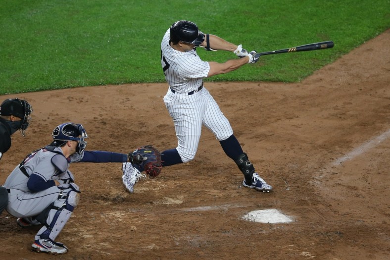 May 5, 2021; Bronx, New York, USA; New York Yankees designated hitter Giancarlo Stanton (27) hits a two run home run against the Houston Astros during the third inning at Yankee Stadium. Mandatory Credit: Brad Penner-USA TODAY Sports