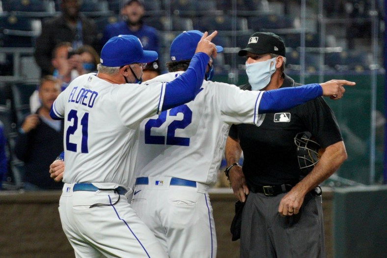 May 5, 2021; Kansas City, Missouri, USA; Kansas City Royals pitching coach Cal Eldred (21) and manager Mike Matheny (22) argue with umpire Angel Hernandez (5) shortly before being ejected in the sixth inning against the Cleveland Indians at Kauffman Stadium. Mandatory Credit: Denny Medley-USA TODAY Sports
