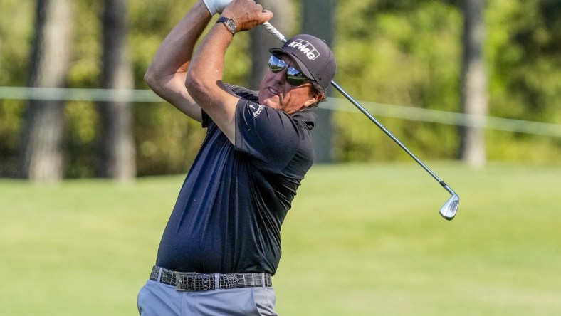 May 6, 2021; Charlotte, North Carolina, USA; Phil Mickelson hits his approach shot to the 9th green during the first round of the Wells Fargo Championship golf tournament. Mandatory Credit: Jim Dedmon-USA TODAY Sports