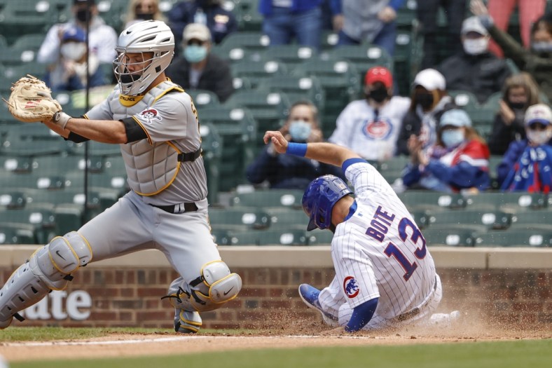 May 7, 2021; Chicago, Illinois, USA; Chicago Cubs second baseman David Bote (13) scores as Pittsburgh Pirates catcher Jacob Stallings (58) waits for the ball during the second inning at Wrigley Field. Mandatory Credit: Kamil Krzaczynski-USA TODAY Sports