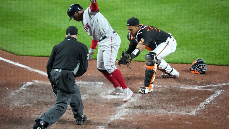 May 7, 2021; Baltimore, Maryland, USA; Boston Red Sox third baseman Rafael Devers (C) scores a run on a single by catcher Christian Vasquez (not pictured) ahead of the tag by Baltimore Orioles catcher Pedro Severino (R) during the eighth inning at Oriole Park at Camden Yards. Mandatory Credit: Mitch Stringer-USA TODAY Sports