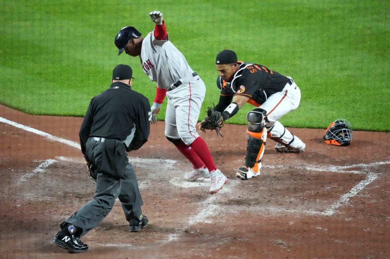 May 7, 2021; Baltimore, Maryland, USA; Boston Red Sox third baseman Rafael Devers (C) scores a run on a single by catcher Christian Vasquez (not pictured) ahead of the tag by Baltimore Orioles catcher Pedro Severino (R) during the eighth inning at Oriole Park at Camden Yards. Mandatory Credit: Mitch Stringer-USA TODAY Sports