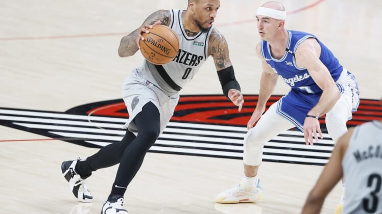 May 7, 2021; Portland, Oregon, USA; Portland Trail Blazers point guard Damian Lillard (0) dribbles the ball as Los Angeles Lakers shooting guard Alex Caruso (right) defends during the second half at Moda Center. Mandatory Credit: Soobum Im-USA TODAY Sports